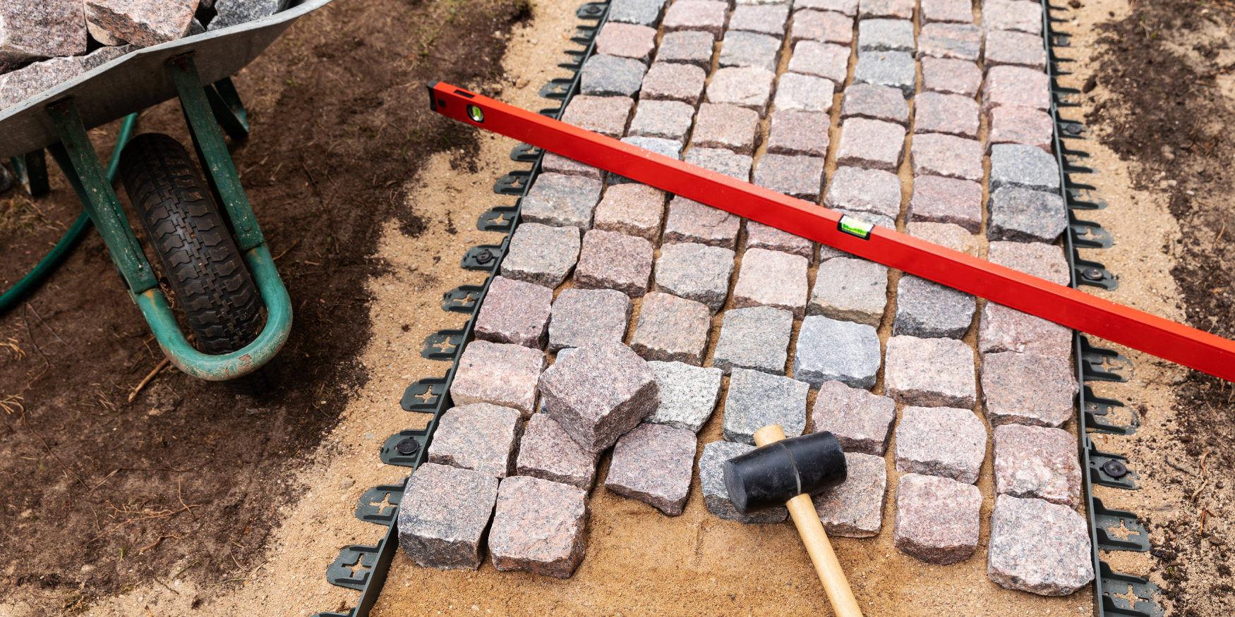 A brick walkway being laid out with tools